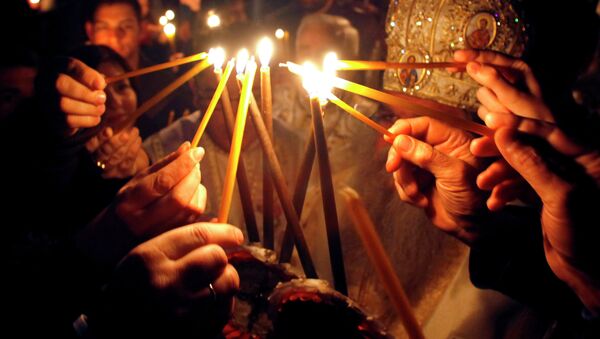 Faithful light candles to participate in a procession at St. Clement Christian Orthodox church in Macedonia's capital Skopje, during Easter service - Sputnik Moldova