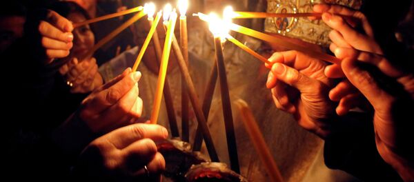 Faithful light candles to participate in a procession at St. Clement Christian Orthodox church in Macedonia's capital Skopje, during Easter service - Sputnik Moldova
