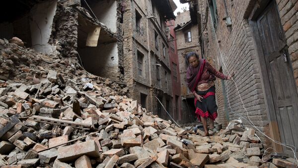 A woman walks across the rubble of a collapsed building following an earthquake in Bhaktapur near Kathmandu, Nepal in this Red Cross handout picture taken on April 28, 2015. - Sputnik Moldova