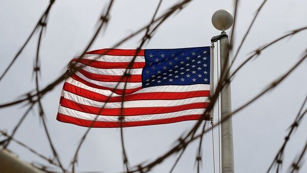 An American Flag is seen through razor wire at Camp VI in Camp Delta where detainees are housed at Naval Station Guantanamo Bay in Cuba - Sputnik Молдова