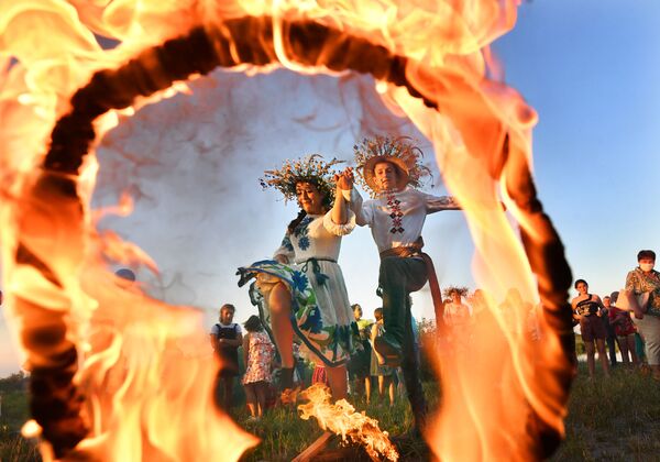 Девушка и юноша прыгают через огонь на празднике Ивана Купалы на берегу залива Припяти в древнем белорусском Турове - Sputnik Молдова