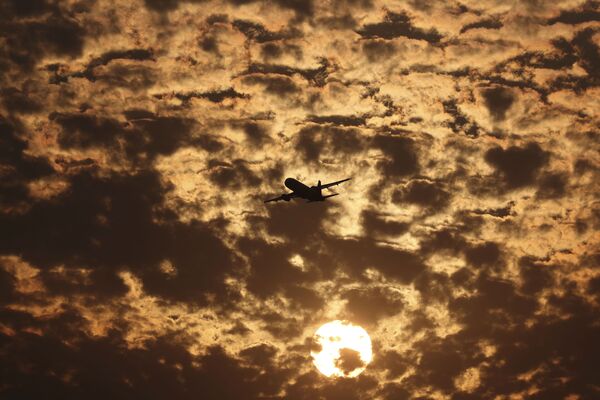 Силуэт самолета на фоне пылающих в заходящем солнце облаков в Ахмедабаде, Индия - Sputnik Молдова