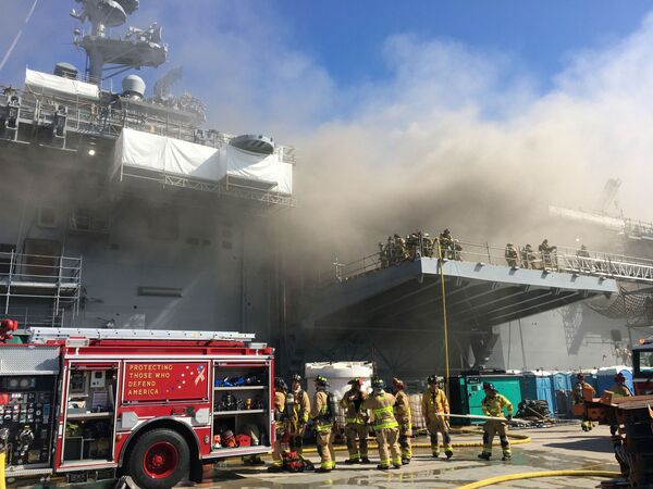 Пожарные и моряки во время тушения пожара на универсальном десантном корабле USS Bonhomme Richard на военно-морской базе США в Сан-Диего - Sputnik Moldova