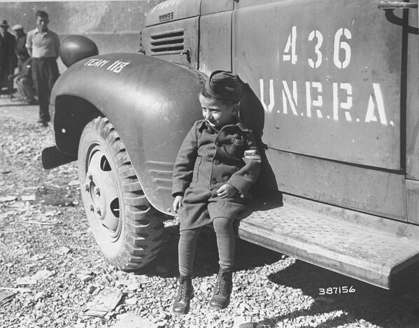 Четырехлетний бывший узник лагеря Бухенвальд около машины UNRRA, 1945 год - Sputnik Moldova-România
