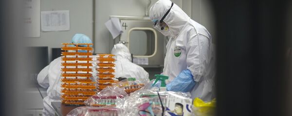 Медицинские работники в защитных костюмах в лаборатории по обнаружению коронавируса - Sputnik Moldova-România