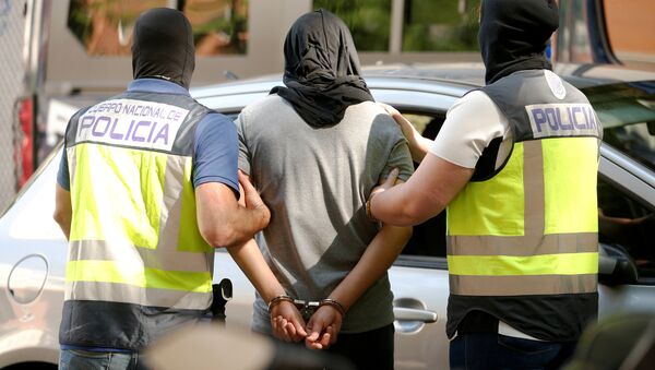 Police lead away a suspect from an apartment block during a raid in which they arrested a 32-year-old Moroccan they said was highly radicalised, in Madrid, Spain June 21, 2017 - Sputnik Moldova-România