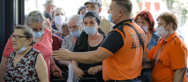 Сотрудники службы безопасности контролируют доступ клиентов к продовольственному рынку в Бухаресте, Румыния Сотрудники службы безопасности контролируют доступ клиентов к продовольственному рынку в Бухаресте, Румыния - Sputnik Moldova-România