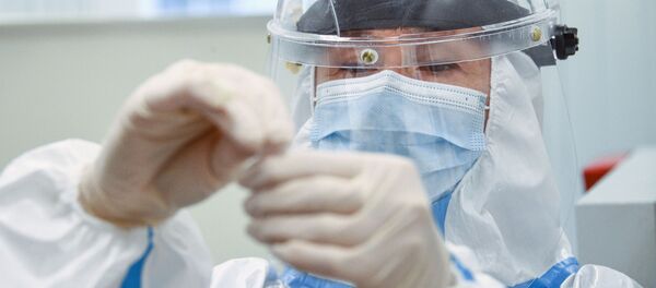 Сотрудник медицинской службы аэропорта Шереметьево проводит экспресс-тестирование на COVID-19 для пассажиров системой EMG - Sputnik Moldova-România