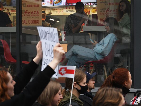 Участники акции протеста идут мимо витрины кафе в Минске - Sputnik Молдова