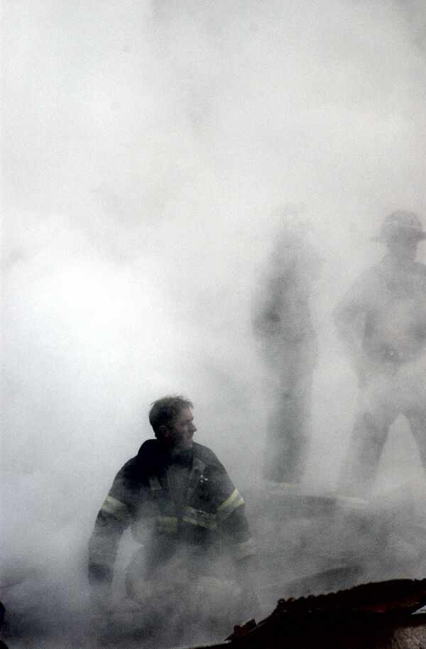 Пожарный в дыму от разрушения Всемирного торгового центра 11 сентября в Нью-Йорке  - Sputnik Молдова