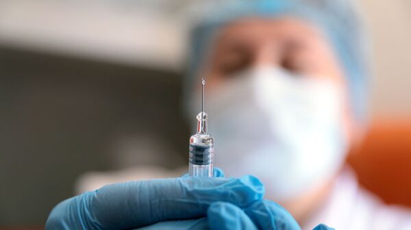Un médecin prépare une seringue avec un vaccin (archive photo) - Sputnik Молдова