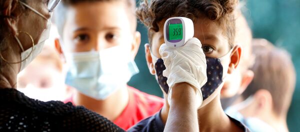 Ученики во время измерения температуры на входе в одну из школ в Риме  - Sputnik Moldova