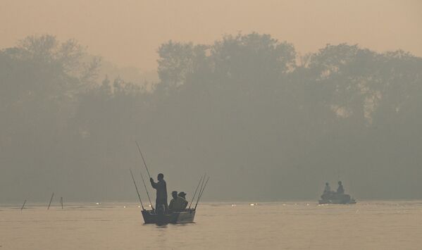 Мужчины рыбачут на затянутой дымом от лесных пожаров реке Cuiaba в Бразилии - Sputnik Moldova-România
