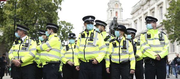 Police officers wearing face masks stand guard during a protest opposed to COVID-19 pandemic restrictions, in Trafalgar Square, London, 29 August, 2020 - Sputnik Moldova-România