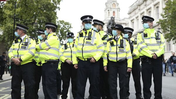 Police officers wearing face masks stand guard during a protest opposed to COVID-19 pandemic restrictions, in Trafalgar Square, London, 29 August, 2020 - Sputnik Moldova-România