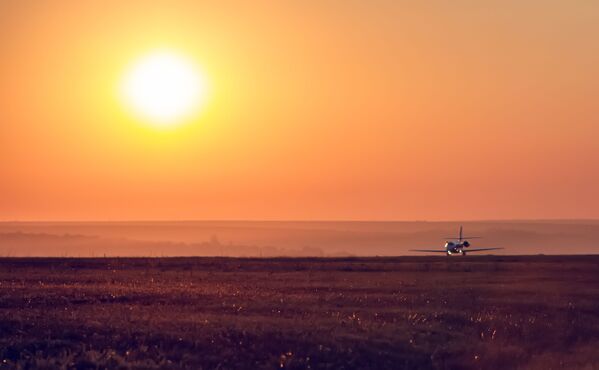 O imagine care îți taie respirația. Un avion care aterizează pe fundalul unui apus extraordinar de soare  - Sputnik Moldova