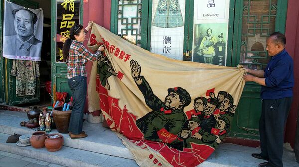 Продавцы разворачивают плакат 1969 года с изображением бывшего китайского лидера Мао Цзэдуна на антикварном рынке в Пекине, Китай - Sputnik Молдова