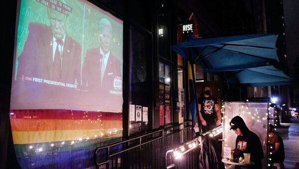Трансляция первых дебатов действующего президента США Дональда Трампа и кандидата в президенты США Джо Байдена на мониторе у входа в бар в верхнем Вест-Сайде в Манхэттене - Sputnik Молдова