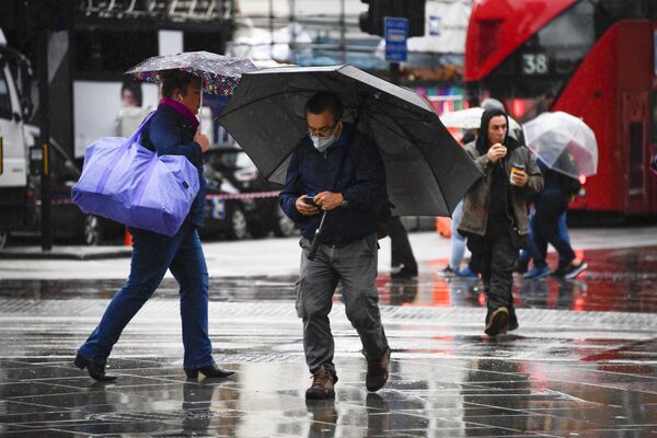 Oameni în ploaie la Piccadilly Circus din Londra - Sputnik Moldova-România