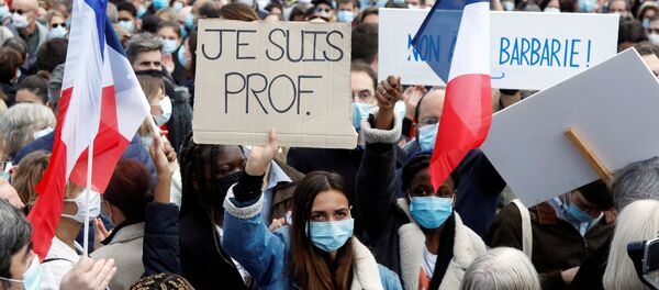 People gather at the Place de la Republique in Paris, to pay tribute to Samuel Paty, the French teacher who was beheaded on the streets of the Paris suburb of Conflans-Sainte-Honorine, France, October 18, 2020.  Placard reads I am a teacher. REUTERS/Charles Platiau - Sputnik Moldova-România