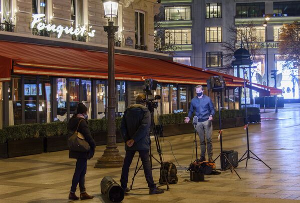 Британские тележурналисты ведут репортаж на Елисейских полях перед знаменитым рестораном FouquetXs во время комендантского час в Париже - Sputnik Молдова