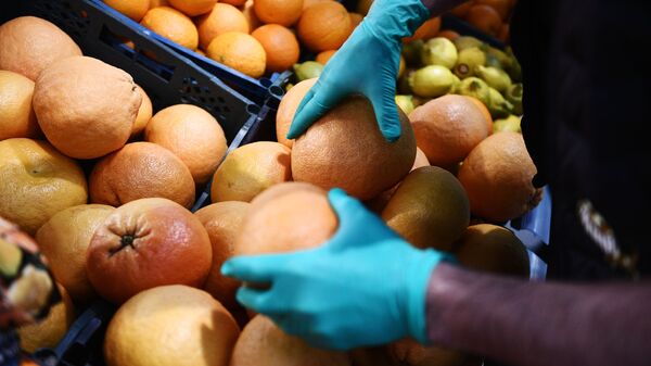 Покупатель выбирает фрукты в продуктовом магазине - Sputnik Молдова