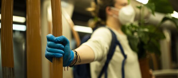 Женщина в защитной маске и перчатках едет в почти пустом транспорте - Sputnik Moldova