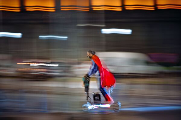 Мужчина в костюме супермена едет на скутере по улице Бухареста, Румыния - Sputnik Moldova-România