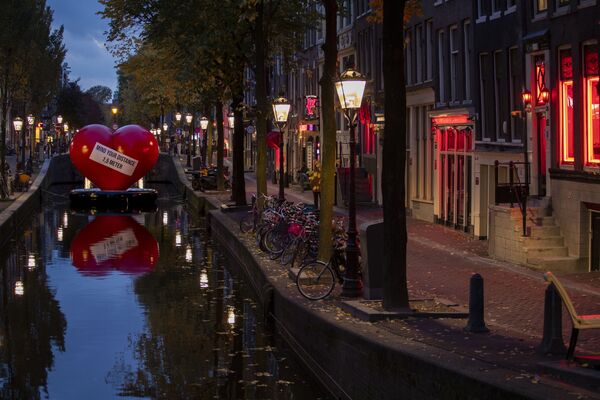 Красное сердце с напоминанием соблюдать социальную дистанцию в почти пустом квартале красных фонарей в Амстердаме, Нидерланды - Sputnik Moldova-România