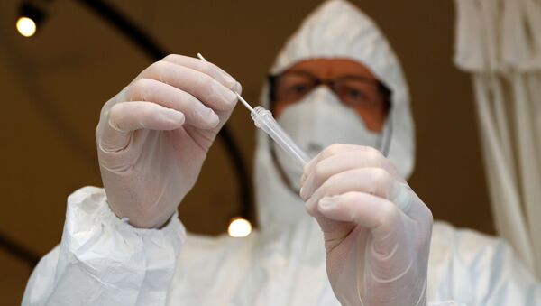 Медицинский персонал держит образец мазка, взятый у человека - Sputnik Moldova-România