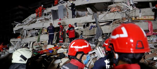Люди работают над обрушившимся зданием в Измире, Турция Люди работают над обрушившимся зданием в Измире, Турция - Sputnik Молдова