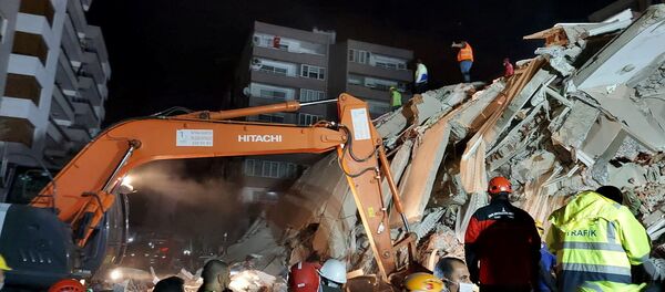 Люди работают над обрушившимся зданием в Измире, Турция - Sputnik Молдова