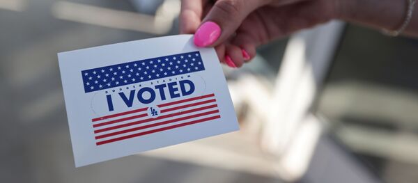 Человек держит наклейку «Я проголосовал» - Sputnik Молдова