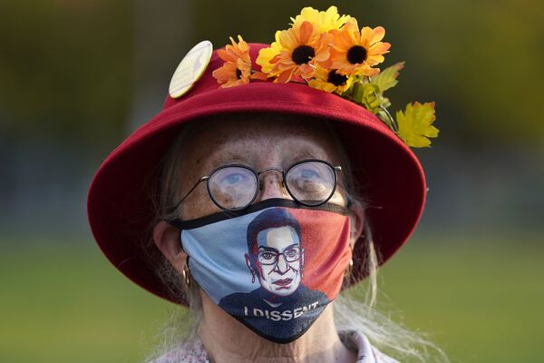 Женщина в маске с портретом судьи Верховного суда Рут Бейдер Гинзбург во время акции протеста в Портленде - Sputnik Moldova-România