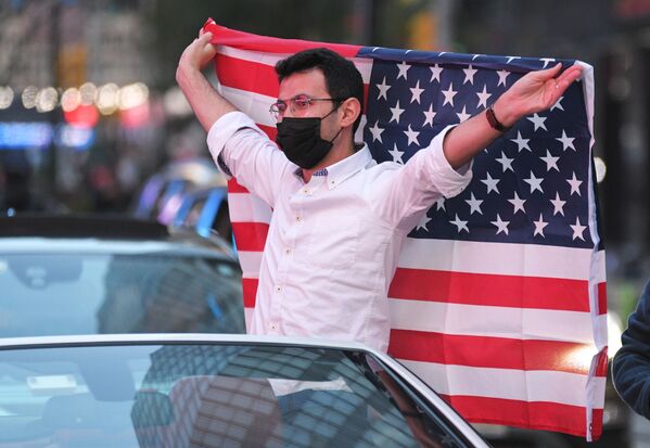 Человек с флагом США на Таймс-сквер в Нью-Йорке после новостей о победе на выборах президента США кандидата от Демократической партии Джозефа Байдена - Sputnik Молдова