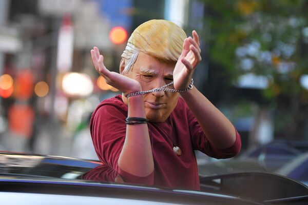 Человек в маске Дональда Трампа едет на машине по улице Нью-Йорка после новостей о победе на выборах президента США кандидата от Демократической партии Джозефа Байдена - Sputnik Молдова