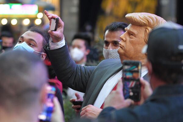 Люди на Таймс-сквер в Нью-Йорке фотографируют человека в маске Дональда Трампа - Sputnik Молдова
