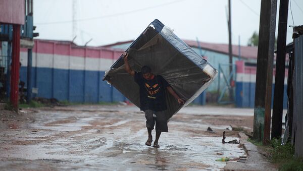 Мужчина с матрасом на одной из улиц Пуэрто-Кабесас в Никарагуа направляется в убежище, спасаясь от надвигающегося урагана Йота - Sputnik Молдова