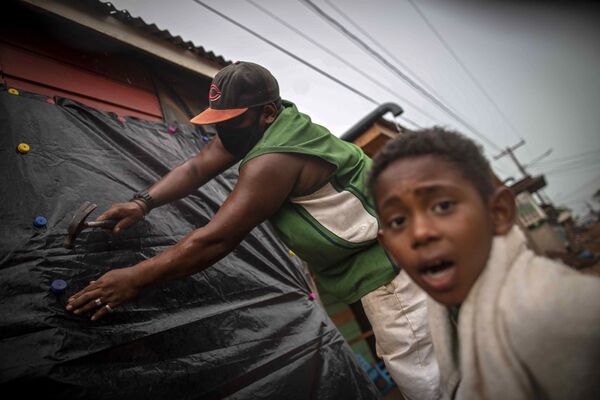 Мужчина закрывает окна своего дома перед ураганом Йота в Бильви, Никарагуа  - Sputnik Молдова