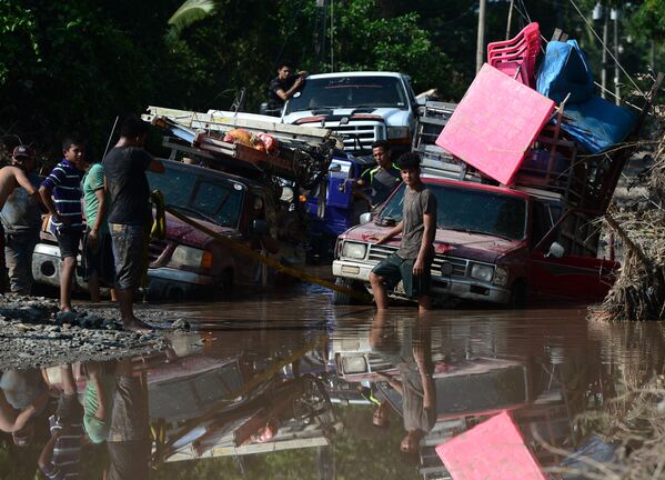 Рабочие на затопленной дороге во время эвакуации в связи с надвигающимся ураганом Йота в Эль-Прогресо, Гондурас - Sputnik Молдова