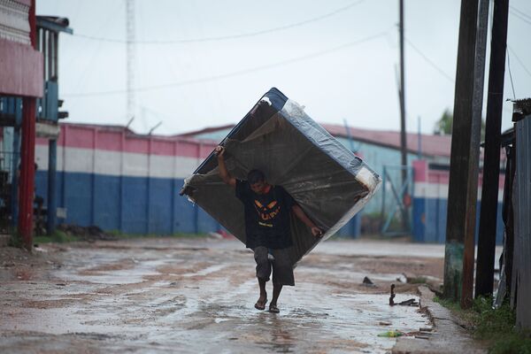 Мужчина с матрасом на одной из улиц Пуэрто-Кабесас в Никарагуа направляется в убежище, спасаясь от надвигающегося урагана Йота - Sputnik Молдова
