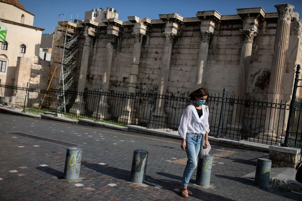 Девушка в защитной маске проходит мимо места археологических раскопок в Библиотеке Адриана во время локдауна, объявленного правительством в связи с коронавирусом, в Афинах, Греция - Sputnik Молдова