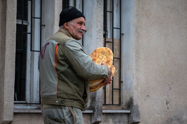 Un bărbat cu  o pâine proaspătă pe o stradă din Stepanakert - Sputnik Moldova-România