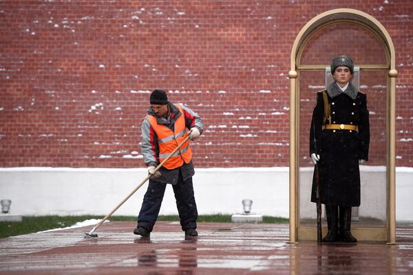 Мужчина убирает снег у Могилы Неизвестного Солдата у стен Московского Кремля - Sputnik Moldova