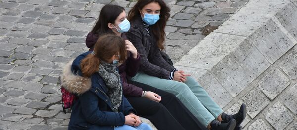 Девушки в масках на площади у входа в музей Лувр в Париже - Sputnik Moldova