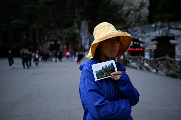  A vendor waits for tourists to take travel photos at the entrance of the Bailong Elevator in Zhangjiajie National Forest Park, China's Hunan province. - Sputnik Moldova-România