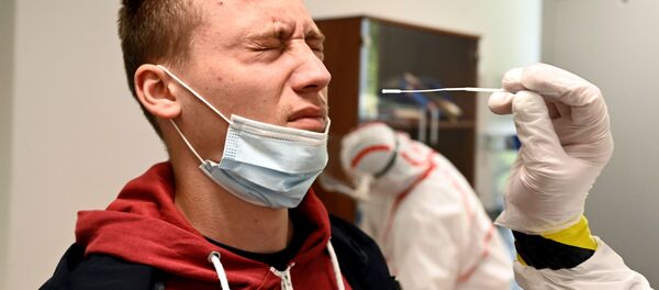 Медицинский работник берет образец мазка у человека на участке тестирования COVID-19 в Оравски-Подзамок, Словакия Медицинский работник берет образец мазка у человека на участке тестирования COVID-19 в Оравски-Подзамок, Словакия - Sputnik Moldova-România