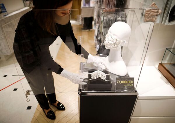 Сотрудник магазина устанавливает маску с драгоценными камнями  в Токио  - Sputnik Moldova-România