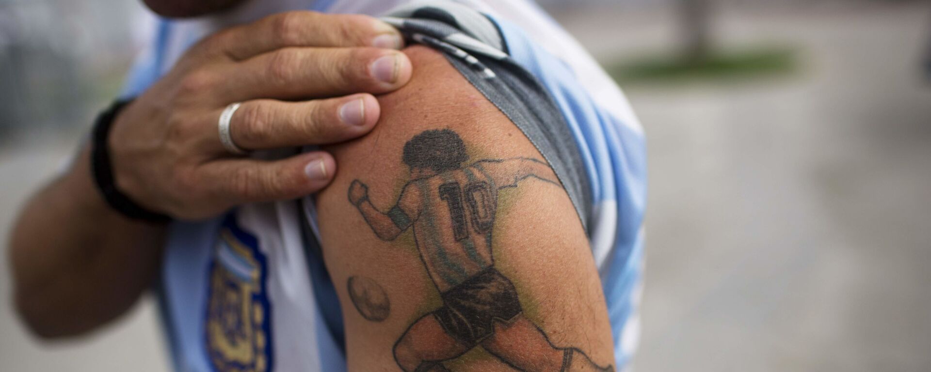 Болельщик с татуировкой на плече с изображением Диего Марадоны в Бразилии  - Sputnik Молдова, 1920, 26.11.2020