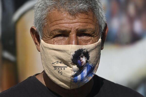Мужчина в маске с изображением Диего Марадоны в Аргентине  - Sputnik Молдова